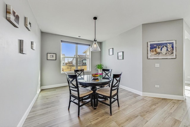 dining room with light wood-style flooring and baseboards