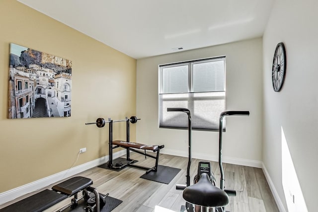 workout area with light wood-type flooring, visible vents, and baseboards