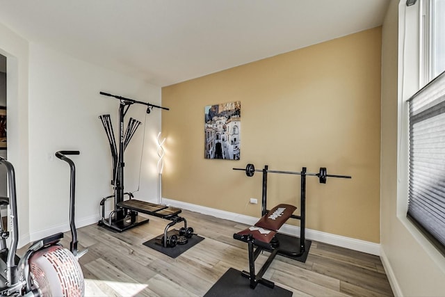 workout room with baseboards and wood finished floors