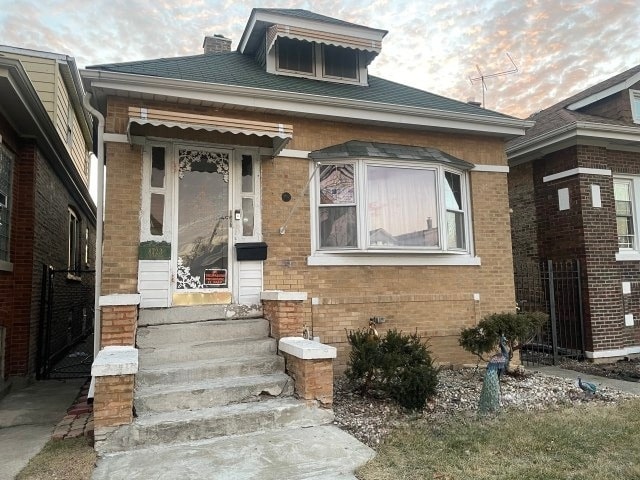 bungalow-style house featuring brick siding