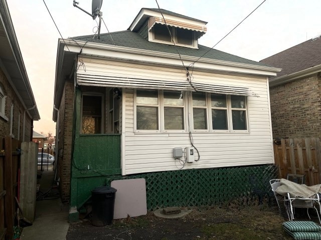 view of side of home featuring fence