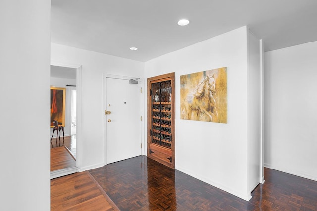 entrance foyer with parquet flooring and recessed lighting