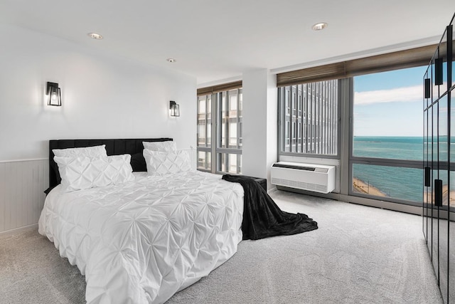 carpeted bedroom featuring access to outside, an AC wall unit, and wainscoting