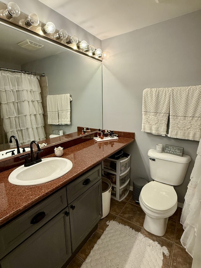 full bathroom featuring visible vents, toilet, vanity, baseboards, and tile patterned floors