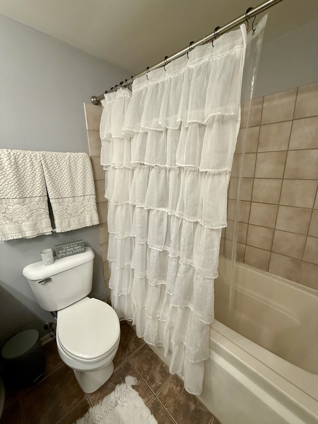 bathroom with tile patterned flooring, shower / tub combo with curtain, and toilet