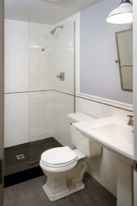 full bathroom with toilet, a shower stall, tile walls, and wood finished floors