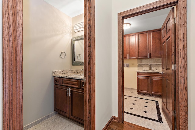 bathroom with tasteful backsplash, baseboards, and vanity