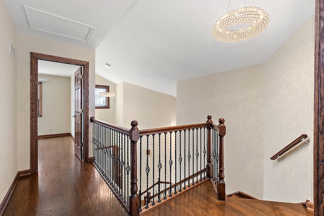 hallway with baseboards, visible vents, lofted ceiling, wood finished floors, and an upstairs landing