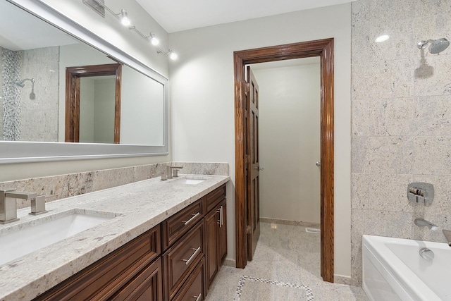 bathroom featuring double vanity, a sink, and baseboards