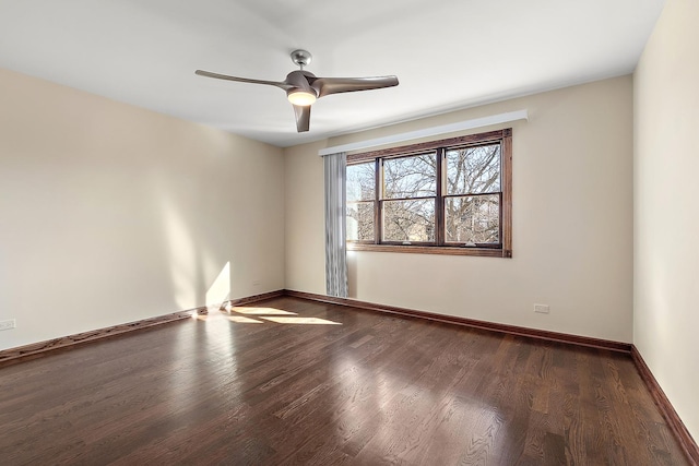 spare room featuring a ceiling fan, baseboards, and wood finished floors