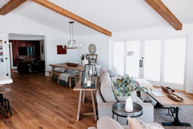 living area featuring vaulted ceiling with beams, a chandelier, and wood finished floors