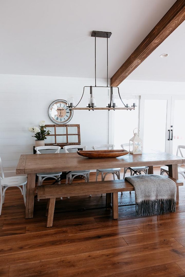 dining area featuring an inviting chandelier, beamed ceiling, and wood finished floors