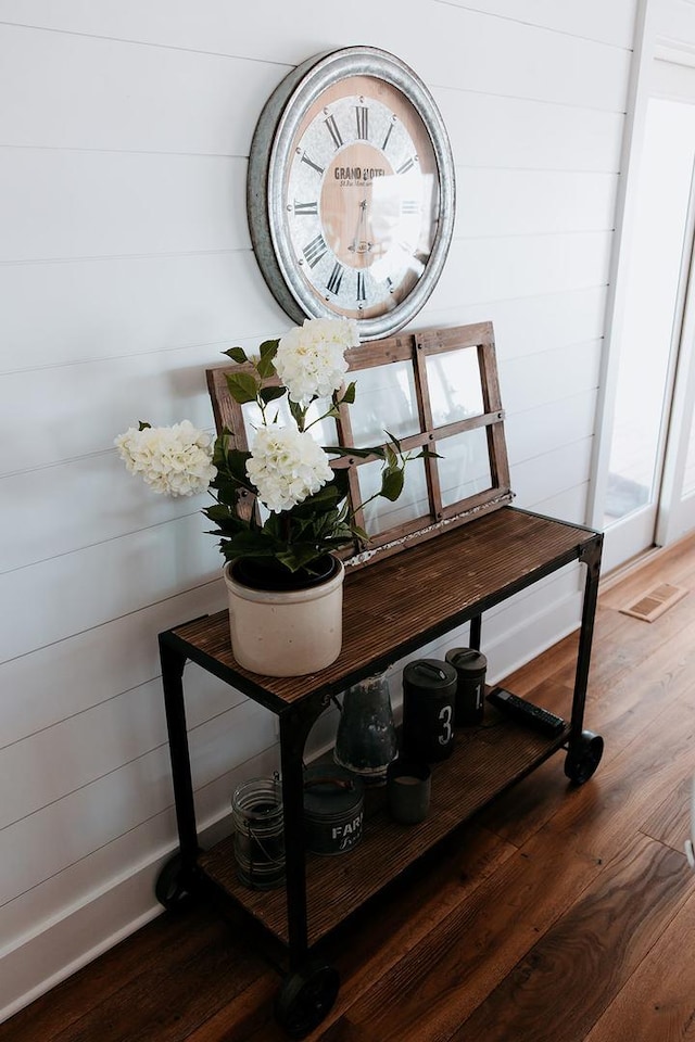 details with wood walls, visible vents, and wood finished floors