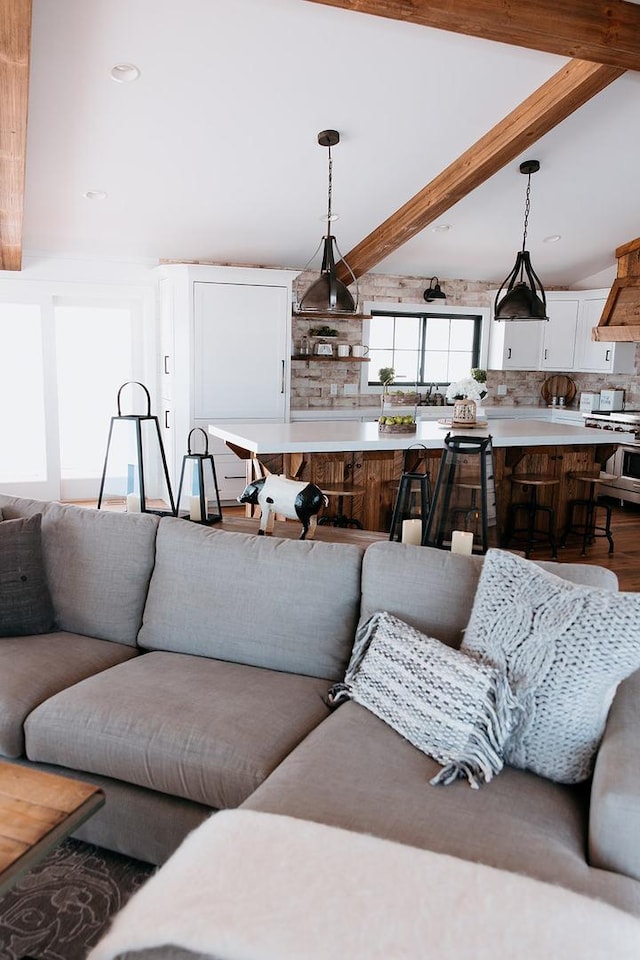 living room featuring beam ceiling and wood finished floors