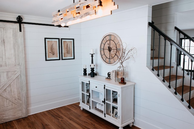 interior space featuring wood finished floors, baseboards, and a barn door