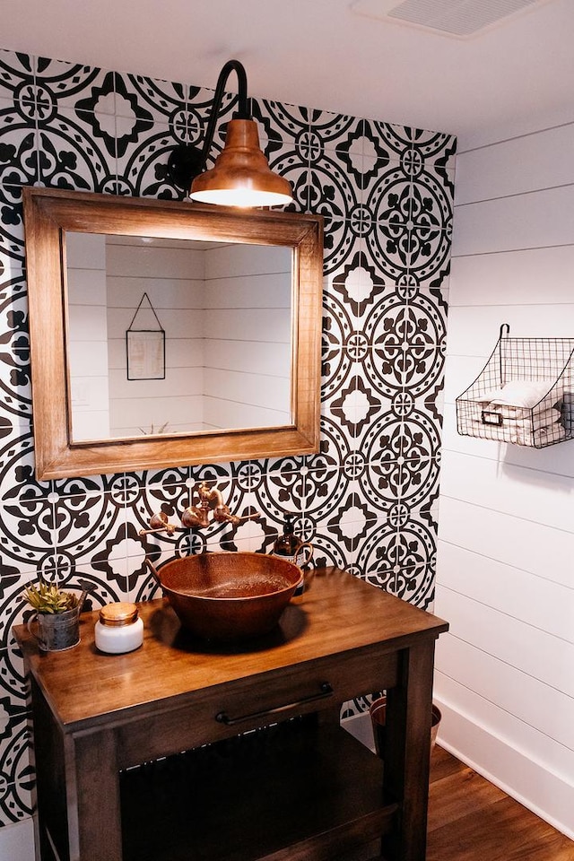 interior space featuring wooden walls, wood finished floors, and vanity