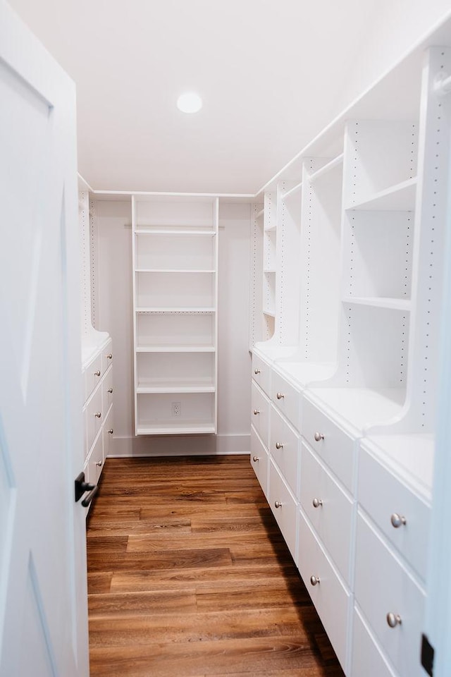 walk in closet with wood finished floors