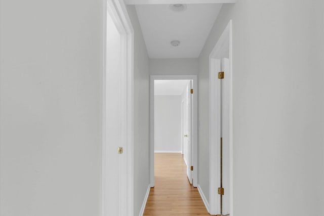 hallway with light wood-style floors and baseboards