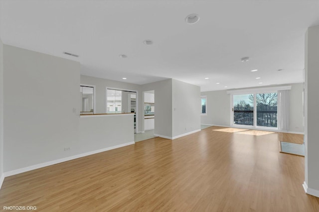 unfurnished living room featuring baseboards, recessed lighting, visible vents, and light wood-style floors