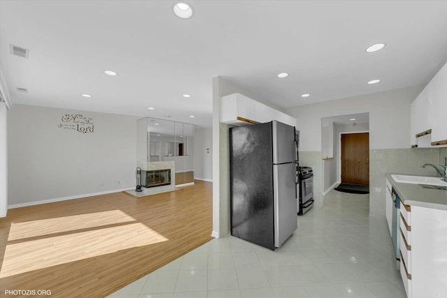 kitchen featuring recessed lighting, a sink, visible vents, white cabinets, and appliances with stainless steel finishes