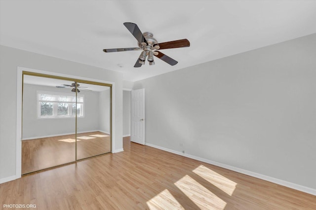 unfurnished bedroom with ceiling fan, a closet, wood finished floors, and baseboards