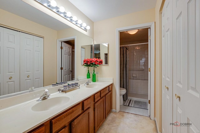 full bathroom featuring double vanity, a closet, a sink, and toilet