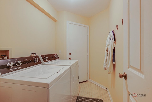 washroom featuring laundry area, baseboards, and washer and dryer