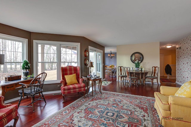 living room with baseboards, a chandelier, and wood finished floors