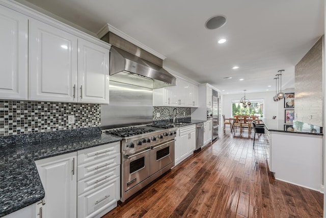 kitchen with appliances with stainless steel finishes, dark wood-style flooring, a sink, and white cabinets