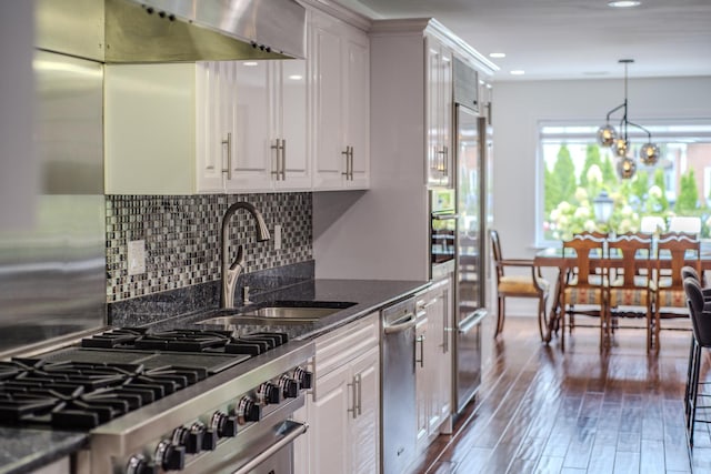 kitchen featuring extractor fan, stainless steel appliances, a sink, white cabinetry, and dark wood finished floors