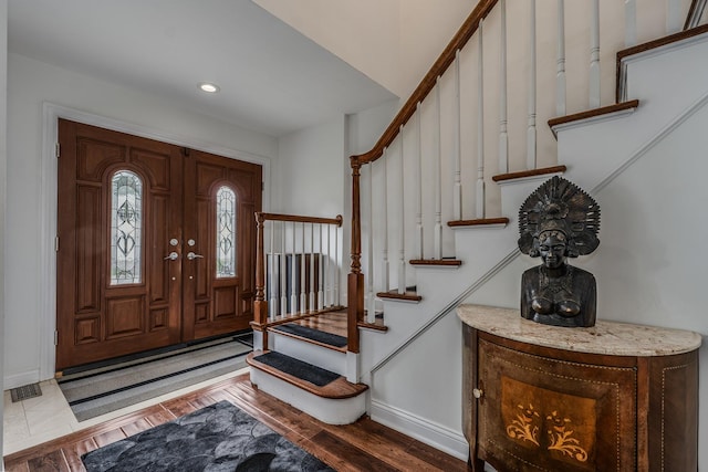 entrance foyer featuring stairs, visible vents, and wood finished floors