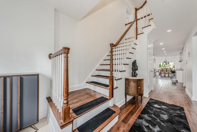 stairway with recessed lighting, baseboards, and wood finished floors