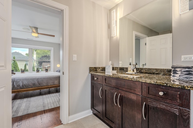 bathroom with a ceiling fan, connected bathroom, vanity, baseboards, and tile patterned floors