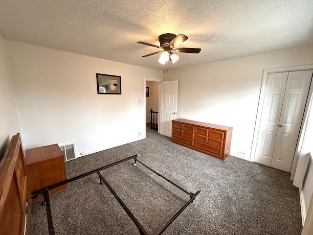 bedroom featuring a textured ceiling, carpet floors, visible vents, a ceiling fan, and a closet