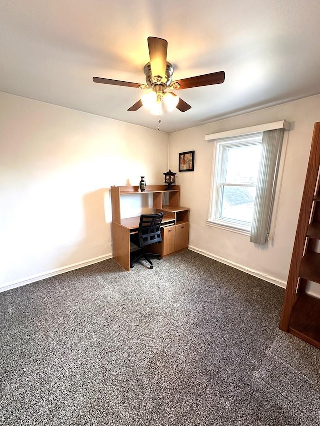 office with a ceiling fan, dark carpet, and baseboards