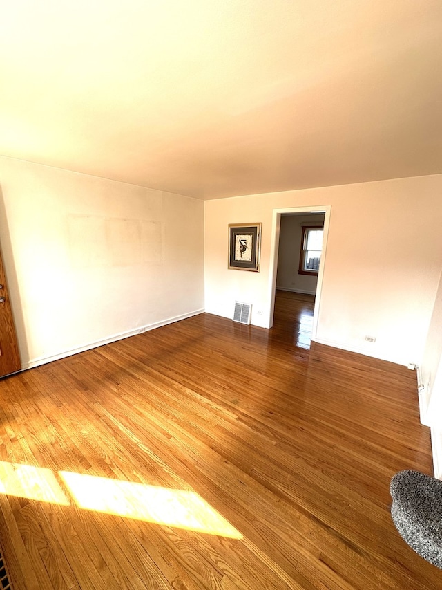 unfurnished room featuring wood finished floors and visible vents