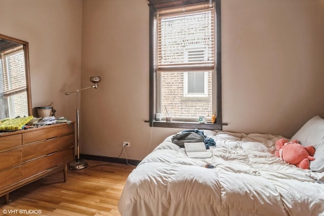 bedroom with wood finished floors and baseboards