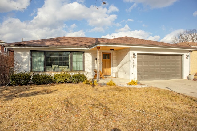 single story home with a garage, brick siding, driveway, roof with shingles, and a front yard