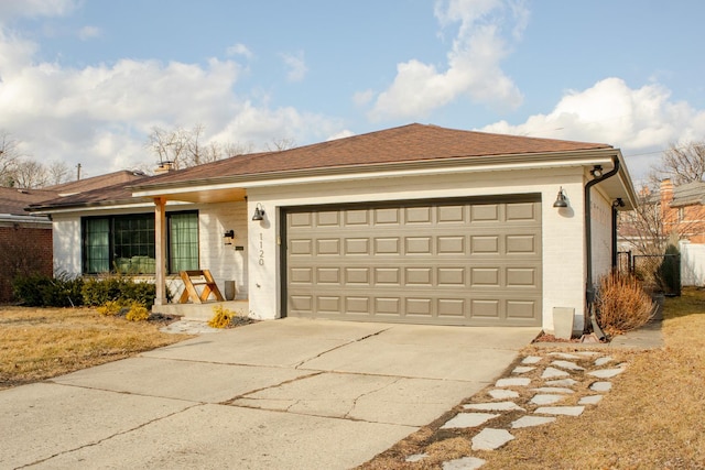 ranch-style home featuring driveway, a shingled roof, a garage, and brick siding