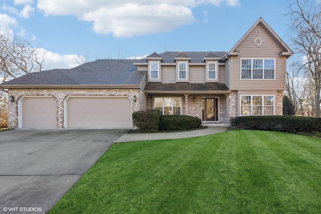 view of front facade with a front yard, brick siding, driveway, and an attached garage