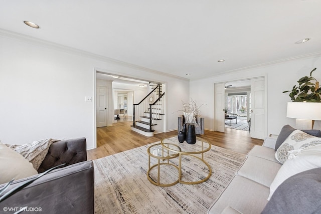 living area featuring ornamental molding, recessed lighting, wood finished floors, and stairs