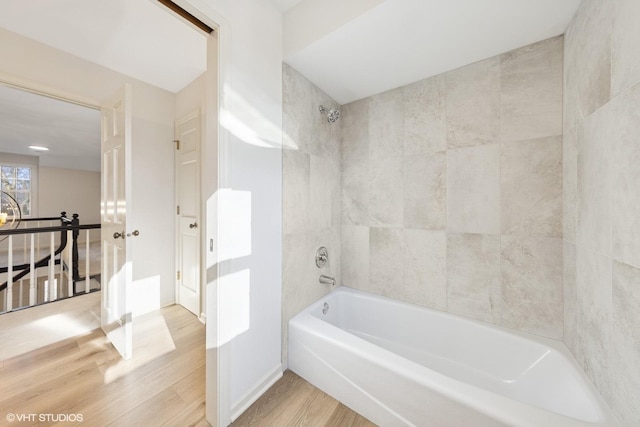 full bathroom with baseboards, wood finished floors, and bathing tub / shower combination