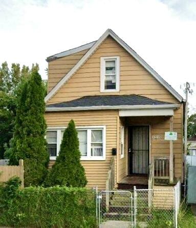 bungalow with a fenced front yard and a gate