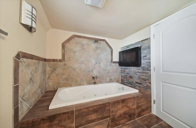 bathroom with tile patterned flooring and a whirlpool tub