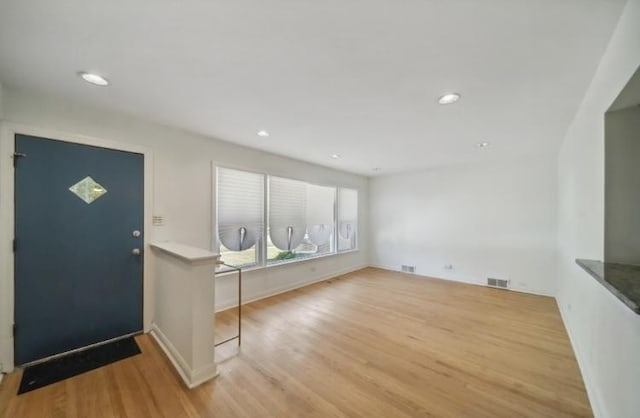 foyer with wood finished floors, visible vents, and recessed lighting