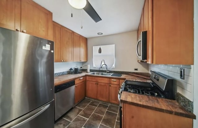 kitchen with brown cabinetry, backsplash, stainless steel appliances, and a sink