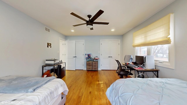 bedroom featuring visible vents, a ceiling fan, light wood-type flooring, multiple closets, and recessed lighting