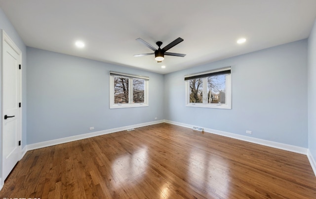 unfurnished room with ceiling fan, recessed lighting, wood finished floors, visible vents, and baseboards