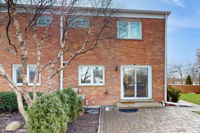 rear view of property featuring a patio area and brick siding