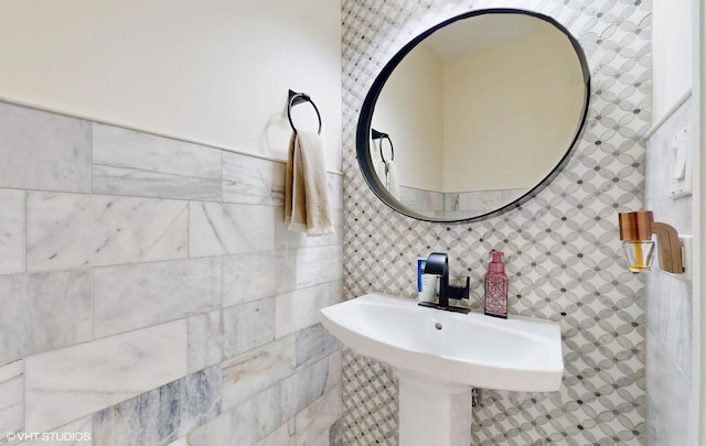 bathroom featuring a sink and tile walls